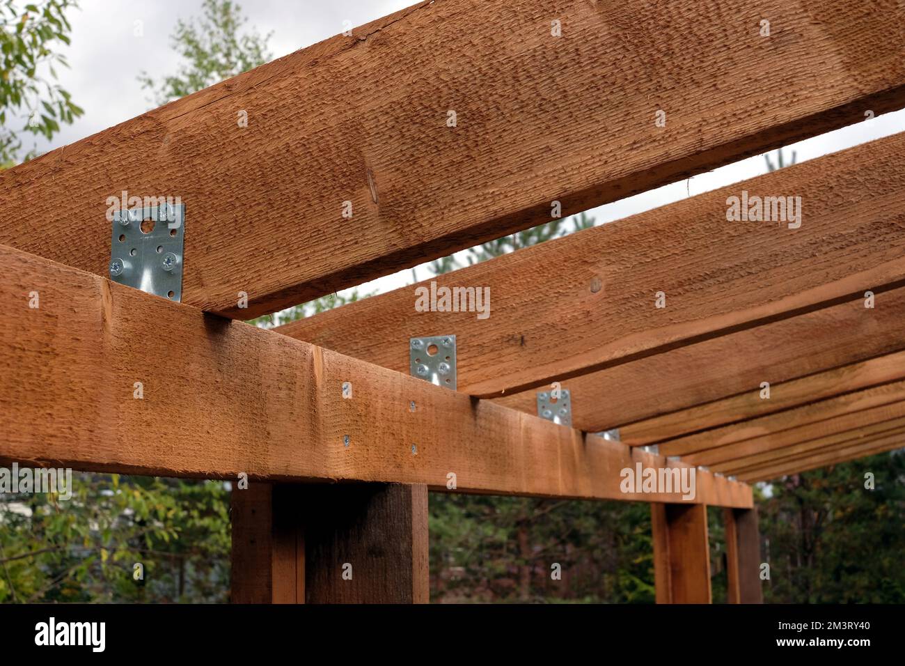 Les chevrons de planches et les angles métalliques vue détaillée en cours de construction d'une voûte en bois dans la campagne Banque D'Images