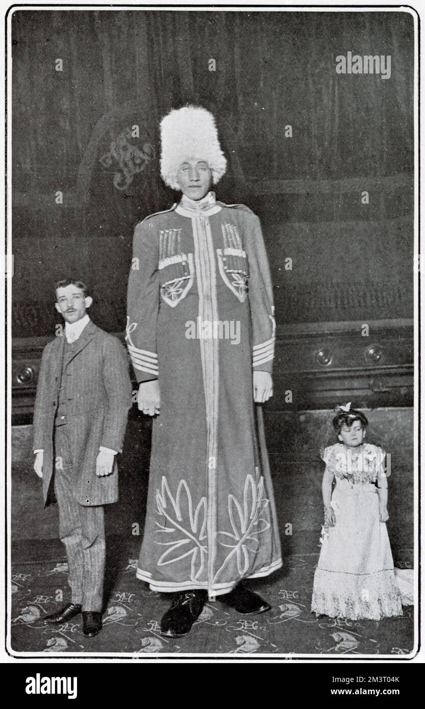 Machnow, le géant russe, photographié dans l'arène de l'hippodrome de Londres avec son directeur, et sa co-star, la haute de dix-huit pouces Madame Chiquita. Machnow aurait une hauteur de 9' 3" mais il était probablement plus susceptible d'être de 7' 10" (encore impressionnant), son chapeau de fourrure ajoutant considérablement à sa taille. Date: 1902 Banque D'Images