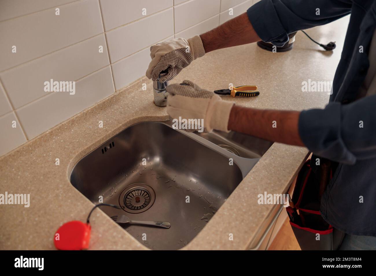 Gros plan du robinet de l'évier de réparation de plombier masculin dans la  cuisine. Service de plomberie de bonne qualité Photo Stock - Alamy