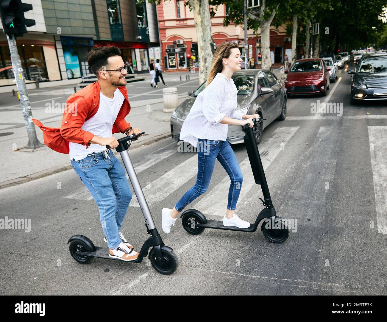 couple jeune scooter électrique ville transport équitation technologie lifesylestreet ami conduite moderne Banque D'Images