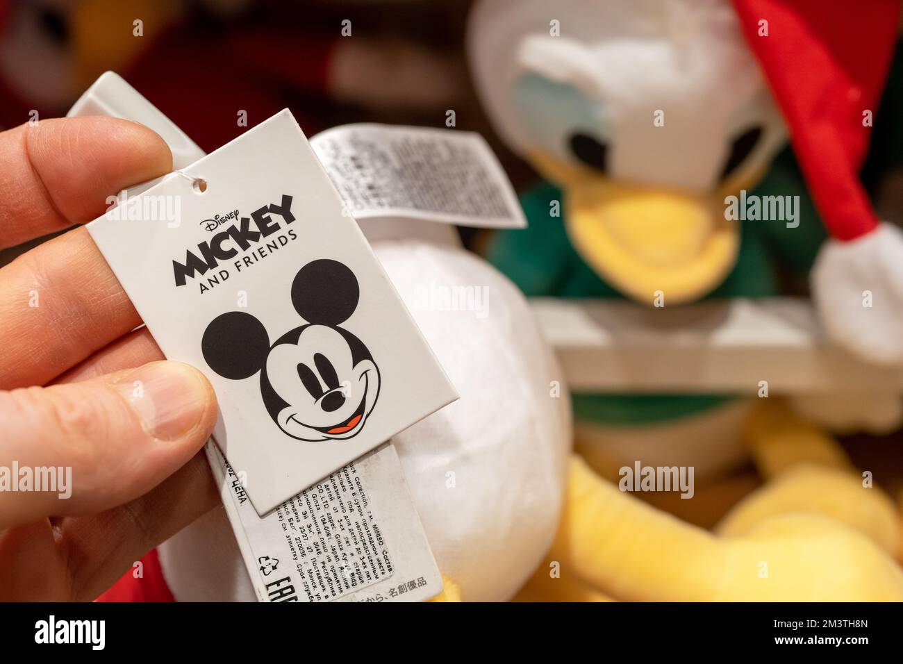Étiquette de jouet Disney portant le logo de l'entreprise entre les mains d'un client dans un magasin. Banque D'Images