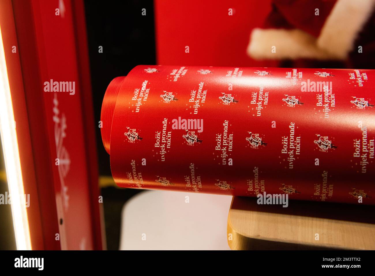Zagreb, Croatie - 8 décembre 2022: Emballage cadeau dans le papier rouge de marque Coca Cola pour Noël en Croatie. Il dit Joyeux Noël en croate. Un rouleau Banque D'Images