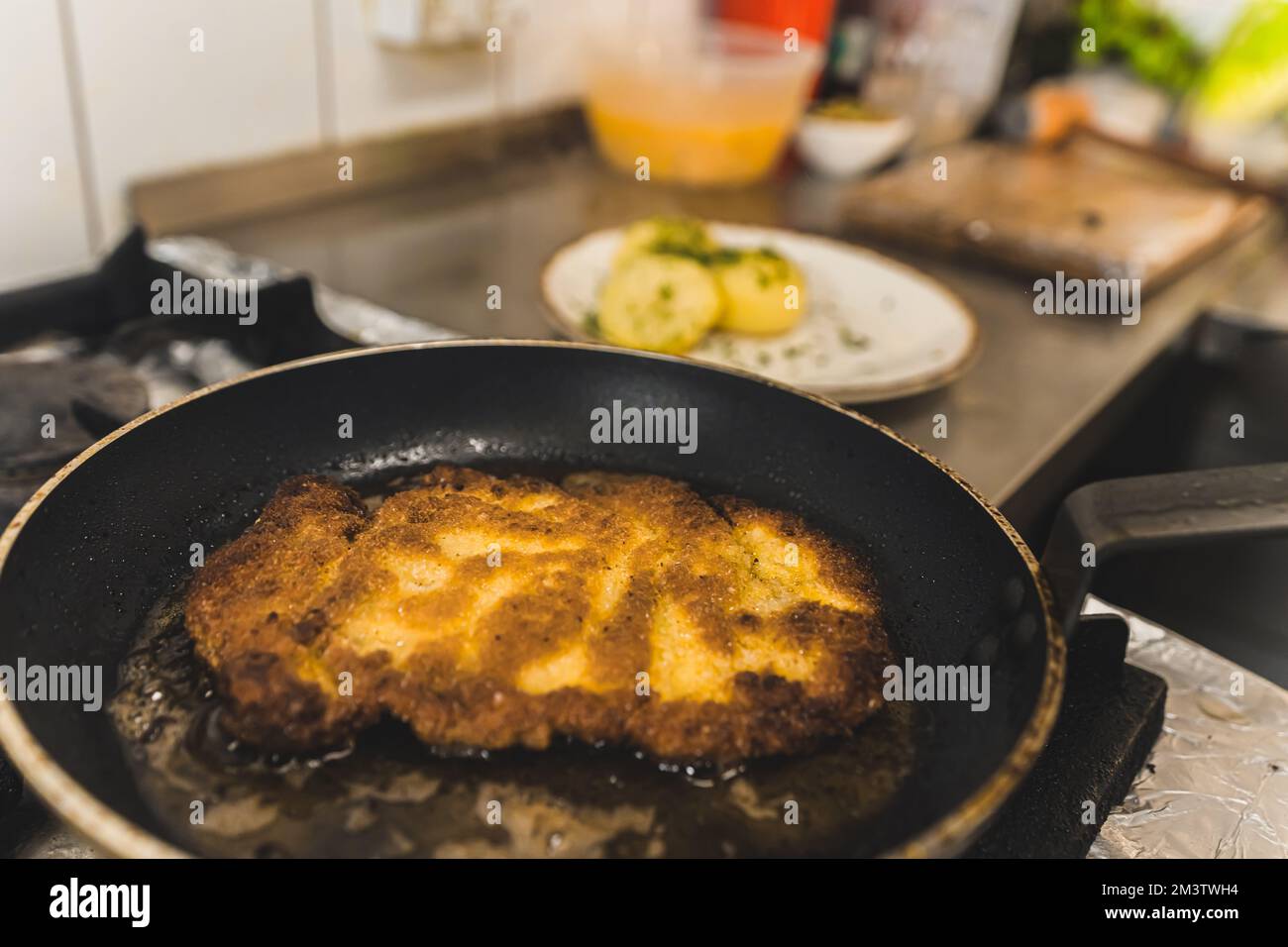 Concept de cuisine polonaise. Processus de friture de la côtelette de porc. Morceau de viande sur une poêle avec de la graisse. Portrait en intérieur. Photo de haute qualité Banque D'Images