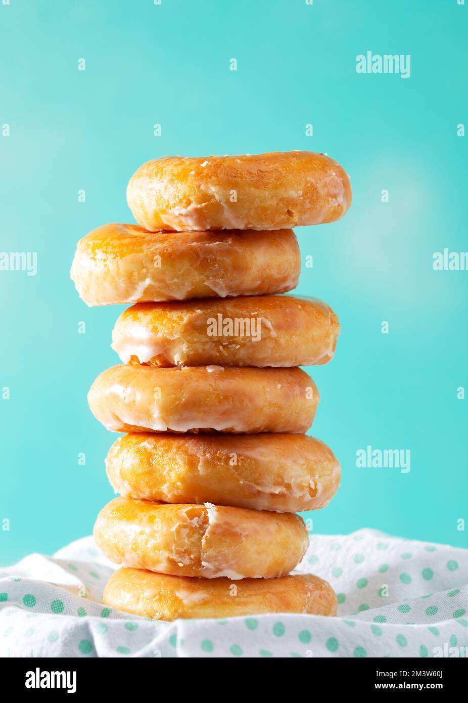 Pile de beignets glacés sur un arrière-plan de couleur aqua avec espace de copie Banque D'Images