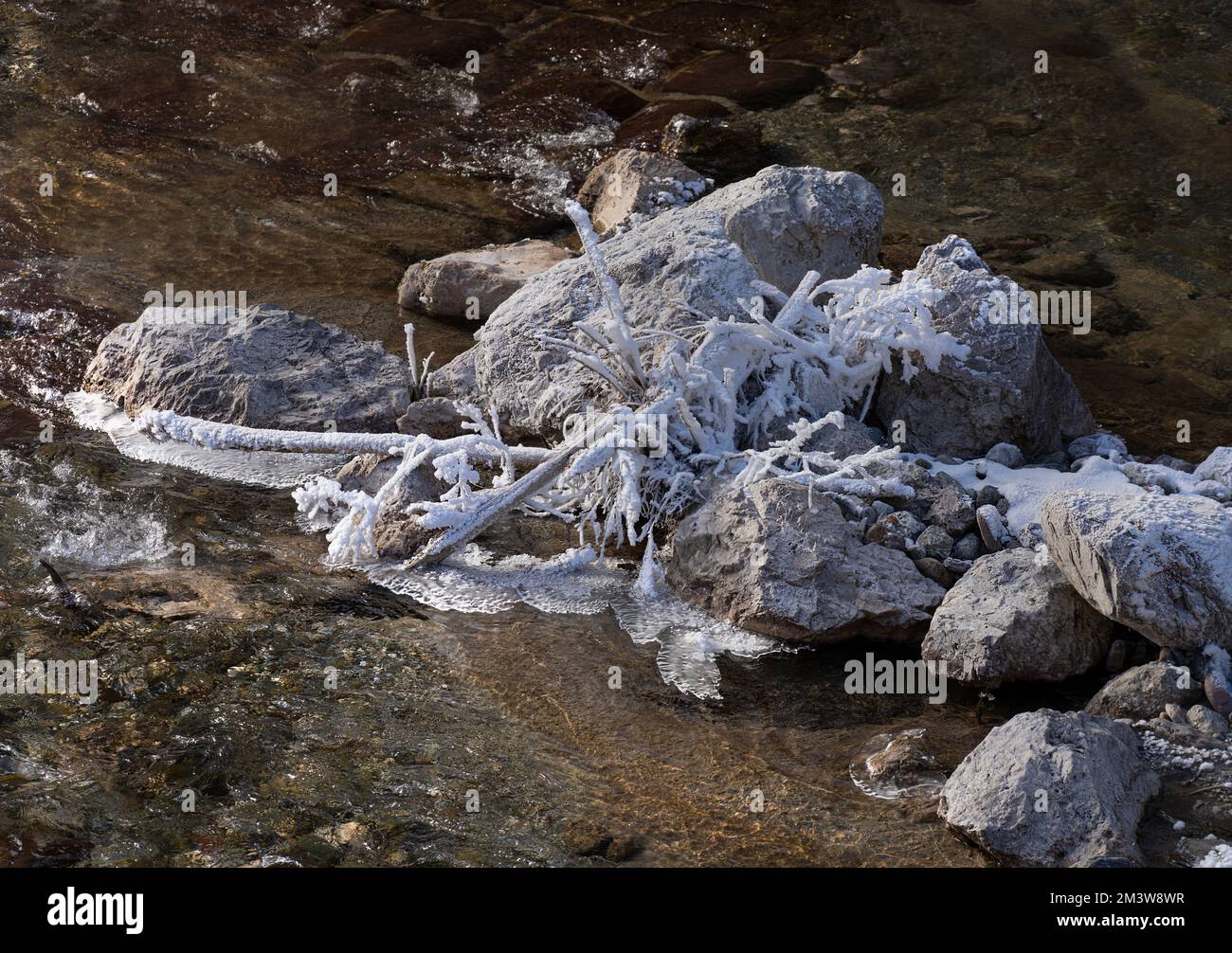 les formations de glace sur les pierres d'un ruisseau en hiver Banque D'Images