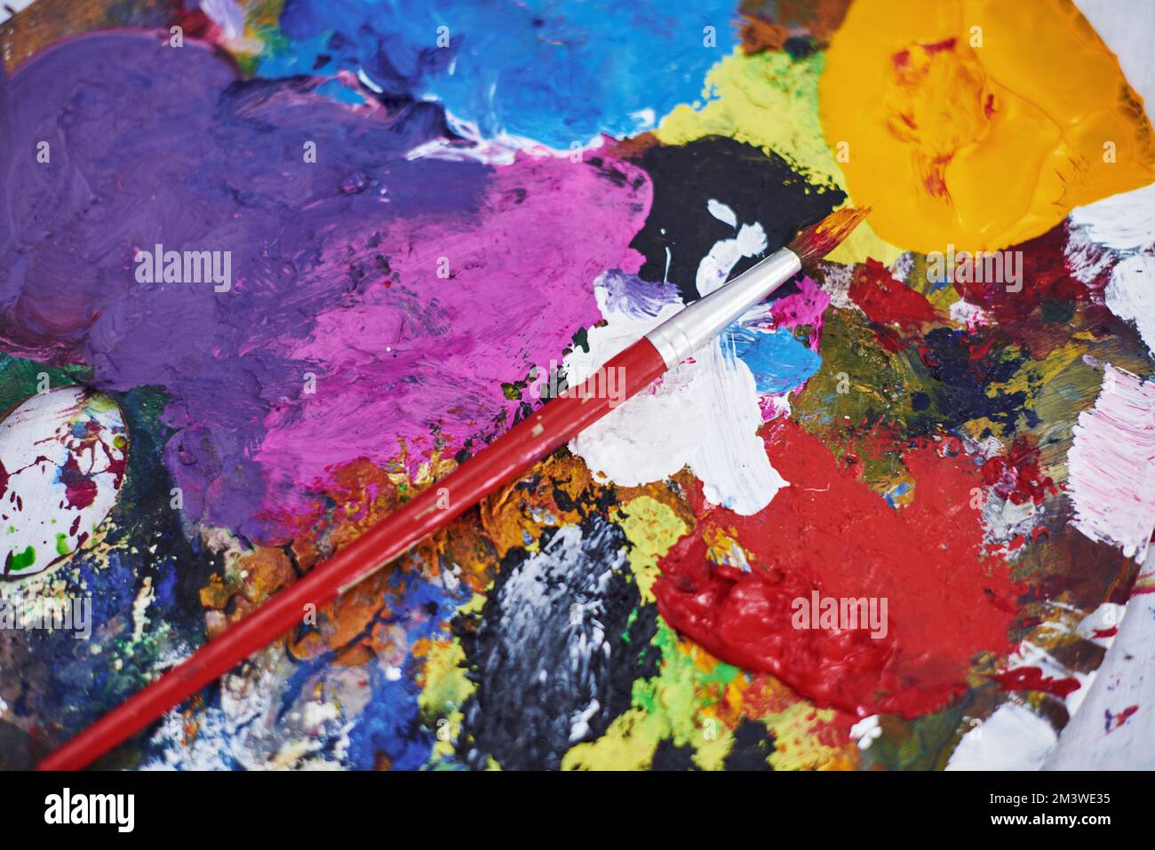 Jouons avec la couleur. Photo d'un pinceau et d'une palette d'artistes d'occasion. Banque D'Images