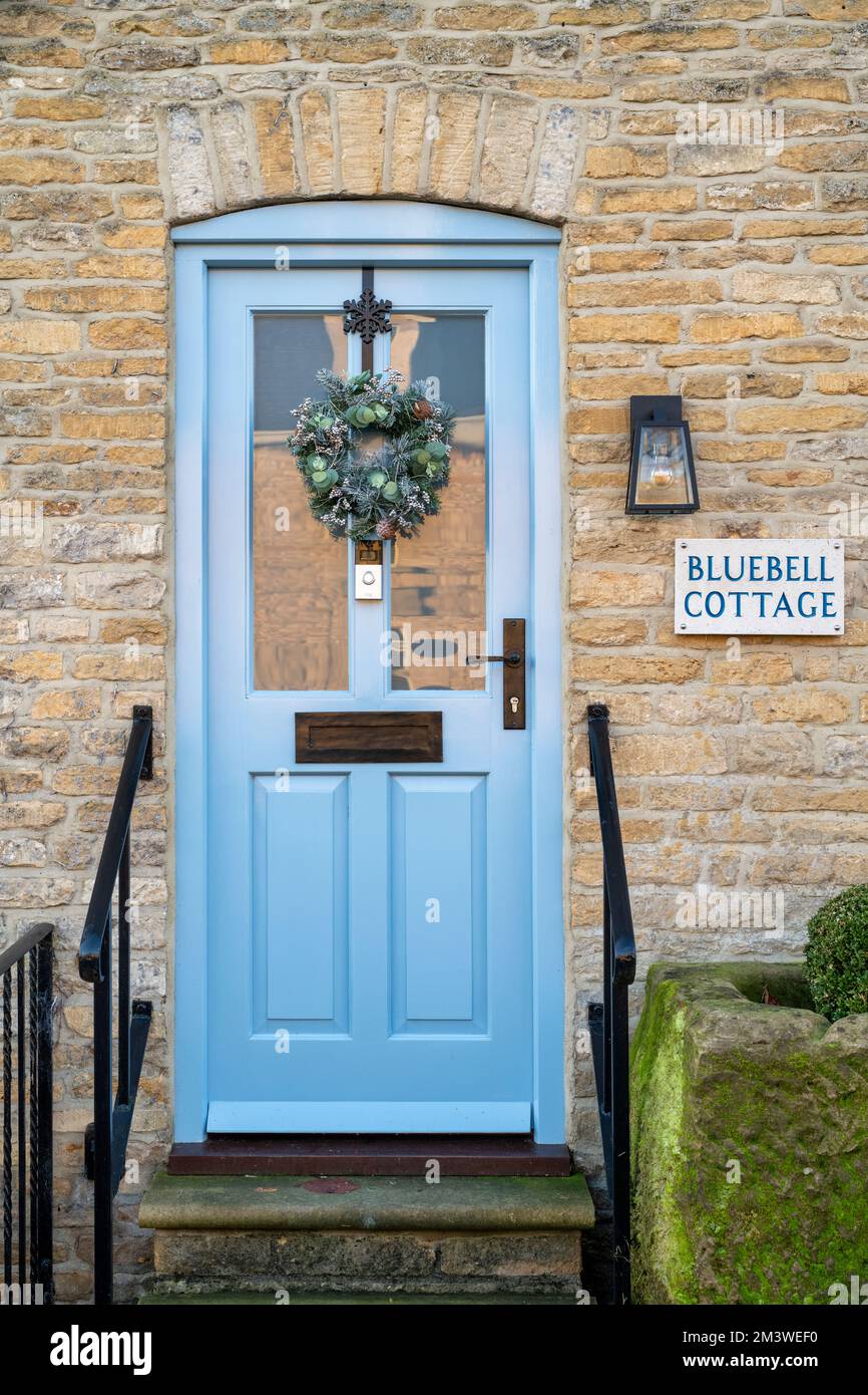 Couronne de Noël sur une porte de chalet en pierre. Stow on the Wold, Cotswolds, Gloucestershire, Angleterre Banque D'Images