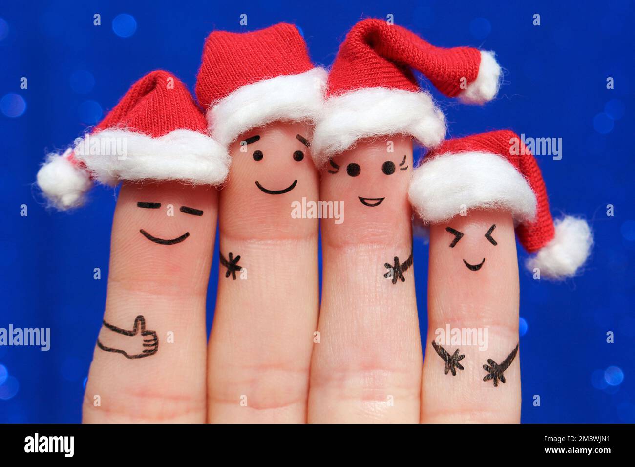 Fingers art of Friends fête Noël. Le concept d'un groupe de personnes riant dans les chapeaux de nouvel an. Banque D'Images