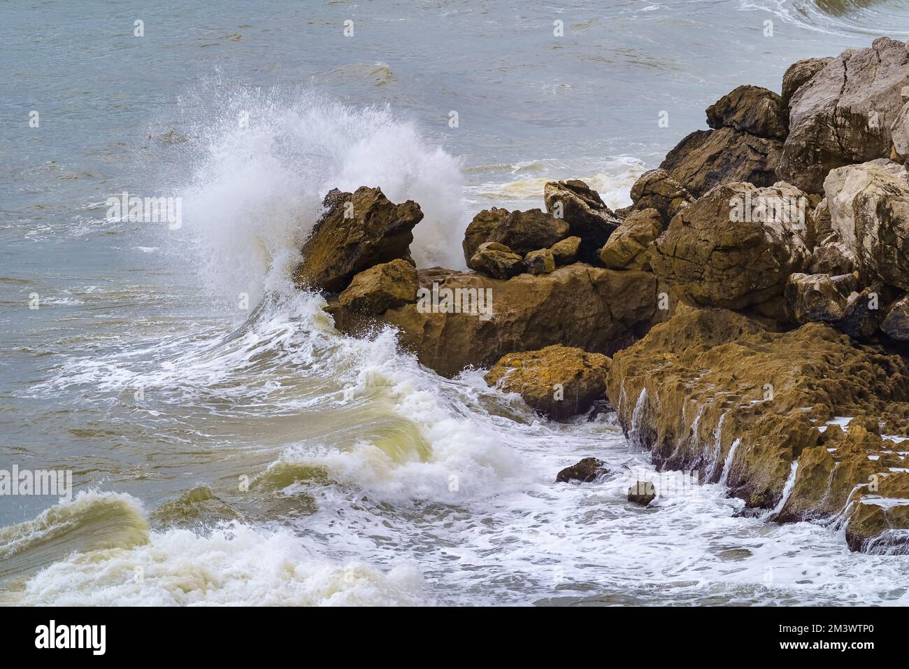 De fortes vagues s'écrasant sur les rochers au large de la côte de Gibraltar par une journée nuageux et des mers agitées. Banque D'Images