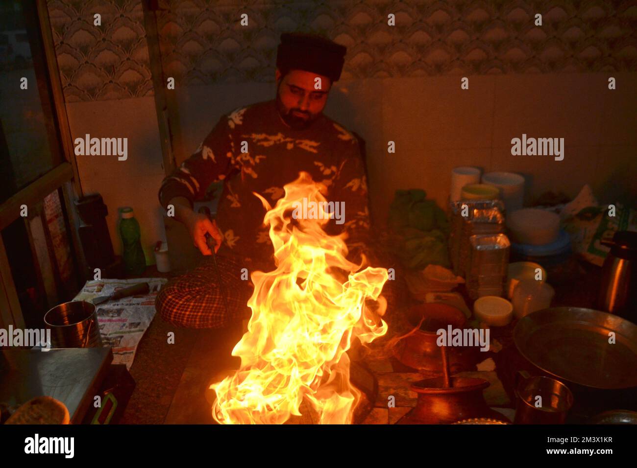 16 décembre 2022, Srinagar, Jammu-et-Cachemire, Inde: Un commerçant verse de l'huile de cuisson chaude sur une assiette contenant un plat à viande, connu localement sous le nom de 'Harisa', avant du servir à ses clients à Srinagar, le 16 décembre 2007. Harisa est un repas préféré que Kashmiris mange tôt le matin en hiver dans des magasins spécialement aménagés appelés la fourgonnette Harisa. (Credit image: © Mubashir Hassan/Pacific Press via ZUMA Press Wire) Banque D'Images