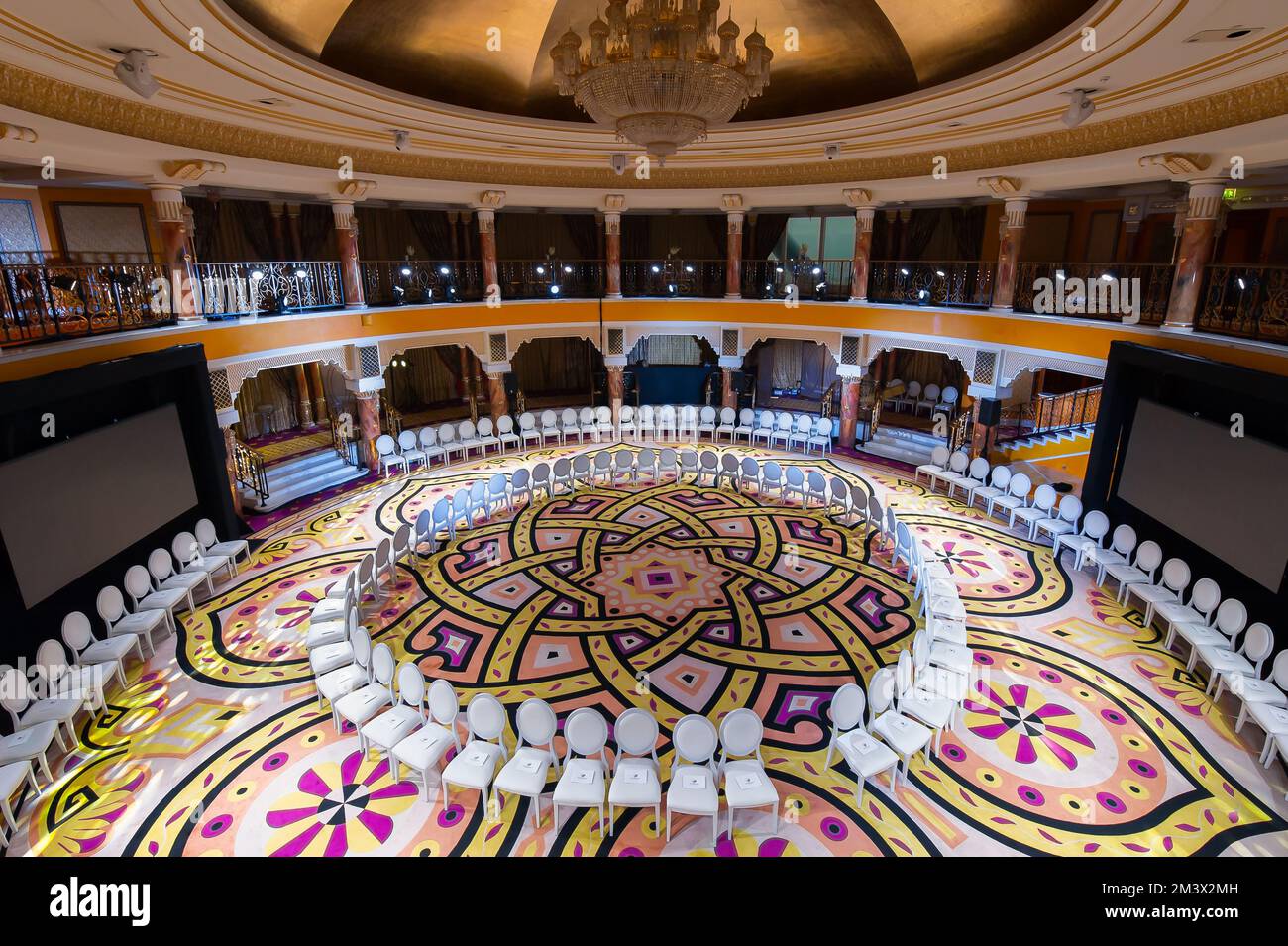 Dubaï, Émirats arabes Unis - Grande salle d'événements ronde de deux étages à l'intérieur de Burj Al Arab. Les chaises blanches forment un cercle. Intérieur d'un hôtel arabe de luxe 7 étoiles. Banque D'Images