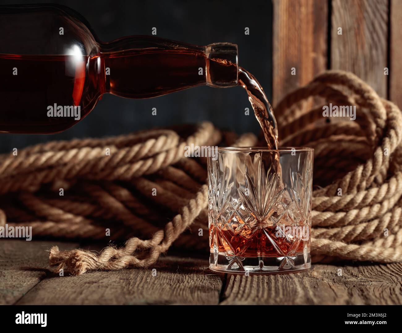 Le rhum, le cognac ou le whisky sont versés dans un verre de cristal ...
