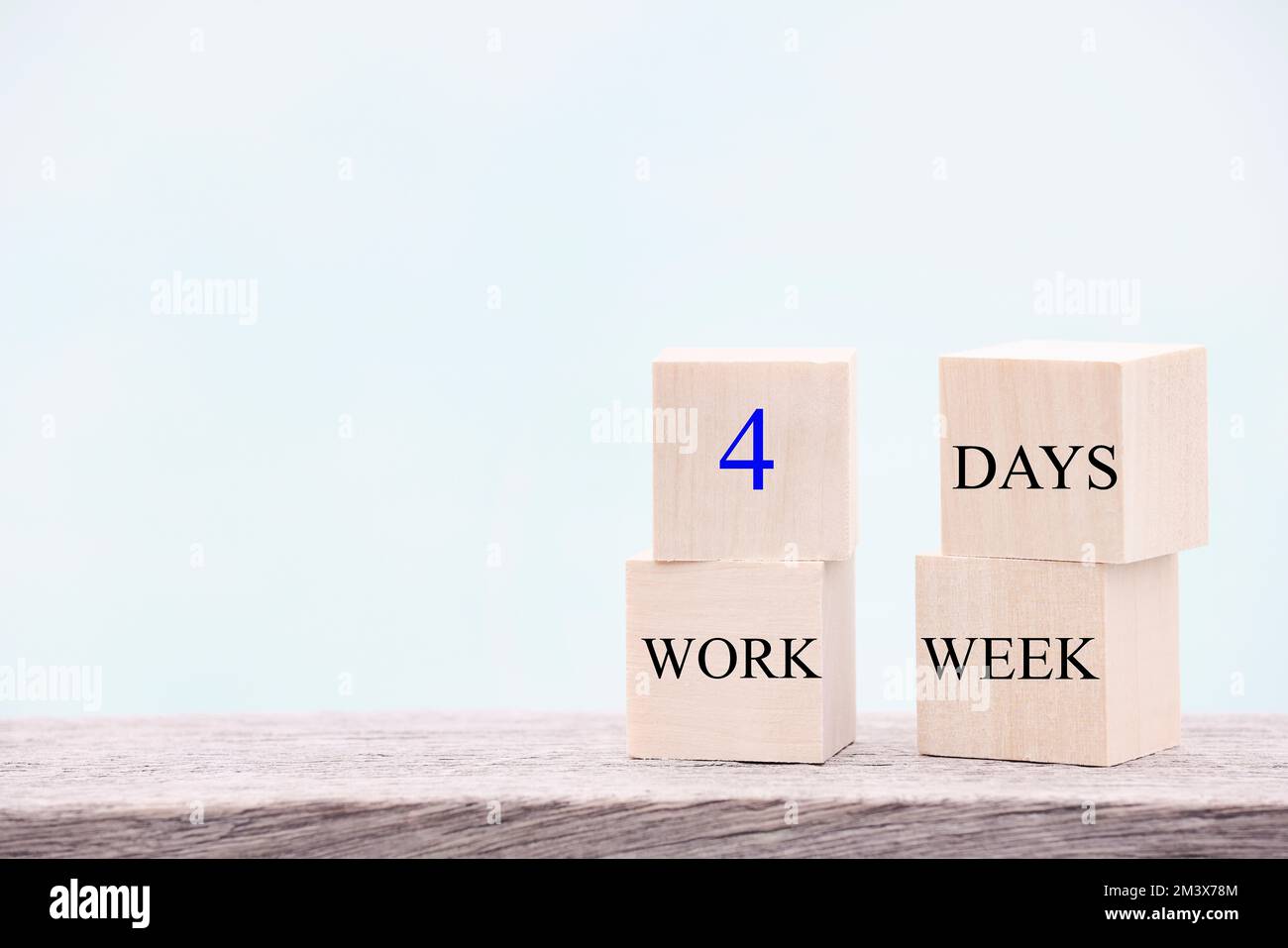 4 jours de travail semaine mots sur cube en bois sur fond bleu. concept de réduction de l'épuisement et des niveaux de stress. copier l'espace Banque D'Images