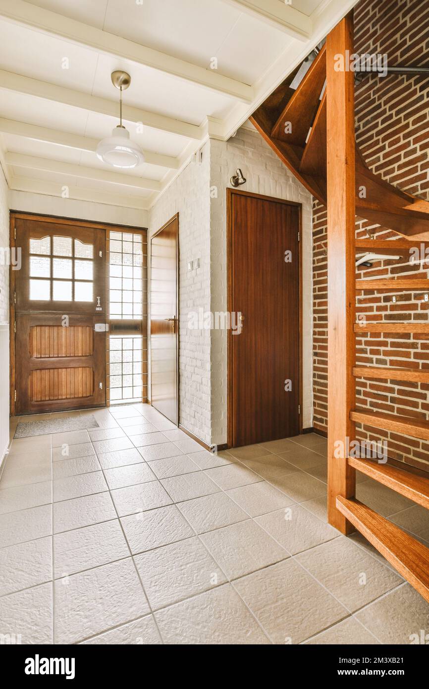 une maison vide avec des murs en bois et en briques blanches de chaque côté de la chambre, il y a un escalier menant à la porte Banque D'Images