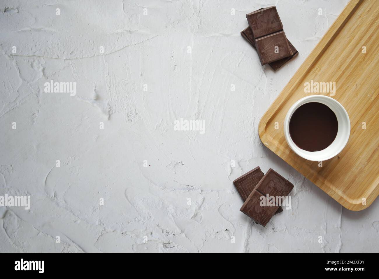 vue de dessus du liquide de chocolat noir et des bonbons sur fond blanc Banque D'Images