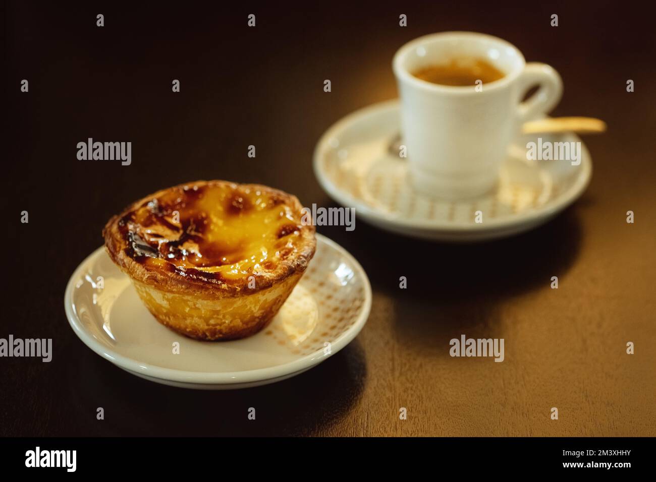 Petit déjeuner portugais d'été. Pastel de nata et petit café. Tarte à la crème aux œufs sur table noire. Banque D'Images