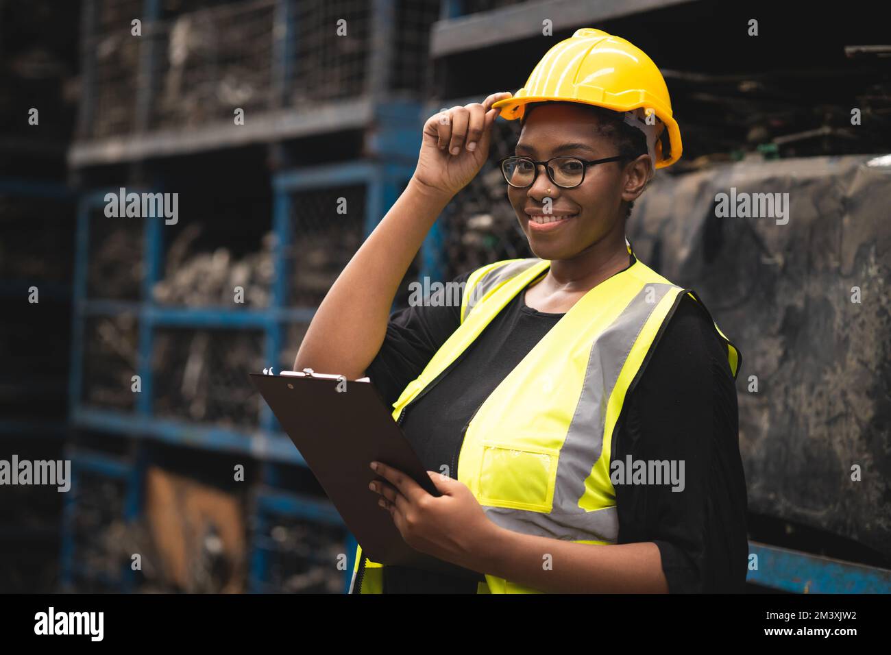 Une femme africaine noire travaille dans l'usine de machines de l'industrie lourde en métal comme équipe d'ingénieurs debout portrait sourire Banque D'Images