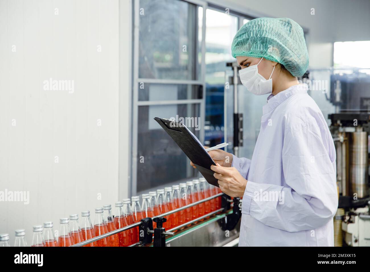 personnel de l'industrie agroalimentaire travaillant sur la chaîne de production du tapis convoyeur dans une usine de boissons avec une zone propre et hygiénique. Banque D'Images