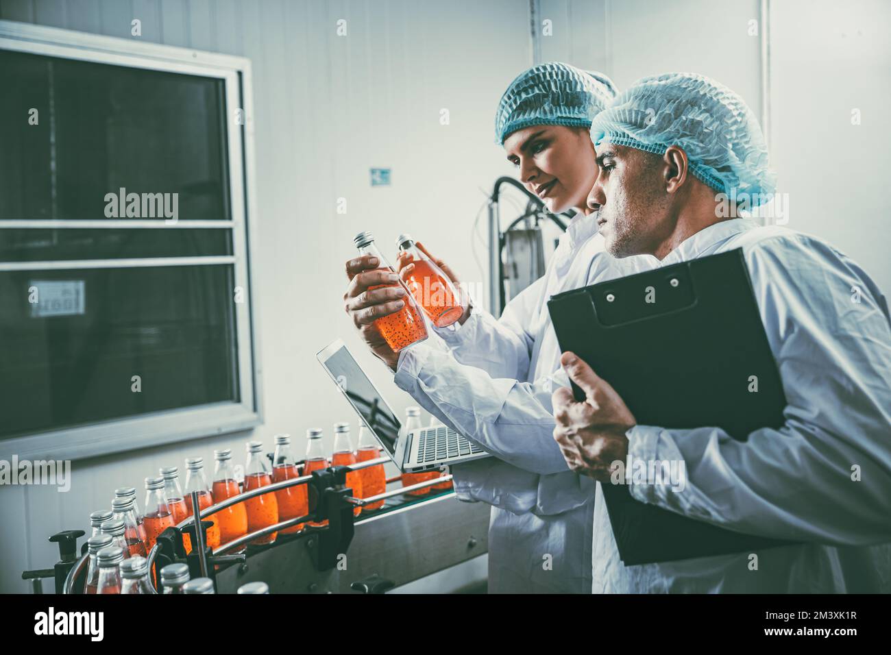 personnel de l'industrie agroalimentaire travaillant sur la chaîne de production du tapis convoyeur dans une usine de boissons avec une zone propre et hygiénique. Banque D'Images
