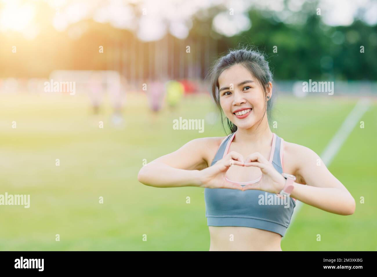 sport teen fille heureux sourire soins de santé activité d'exercice extérieur main amour signe pour les soins vous-même Banque D'Images