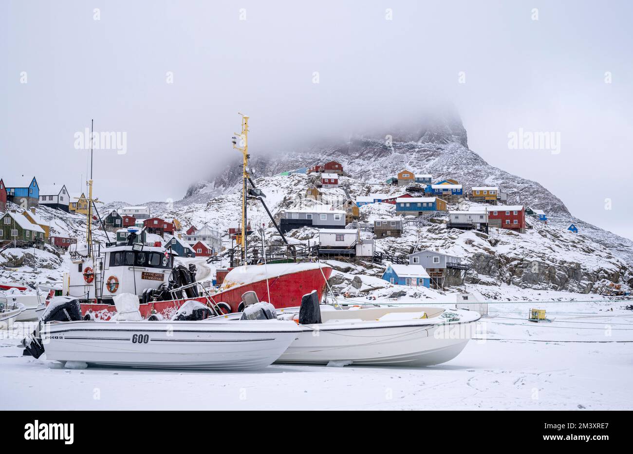 Bateaux de pêche sur la glace de mer dans le port d'Uummannaq, dans l'ouest du Groenland Banque D'Images