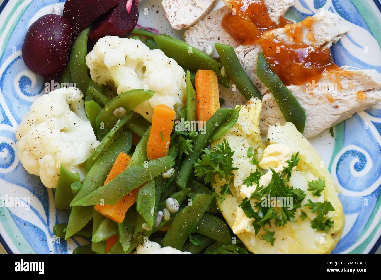Un simple repas nourrissant de poulet froid habillé de chutney de mangue, de pomme de terre de veste et de légumes frais composés de haricots verts, carottes, chou-fleur Banque D'Images