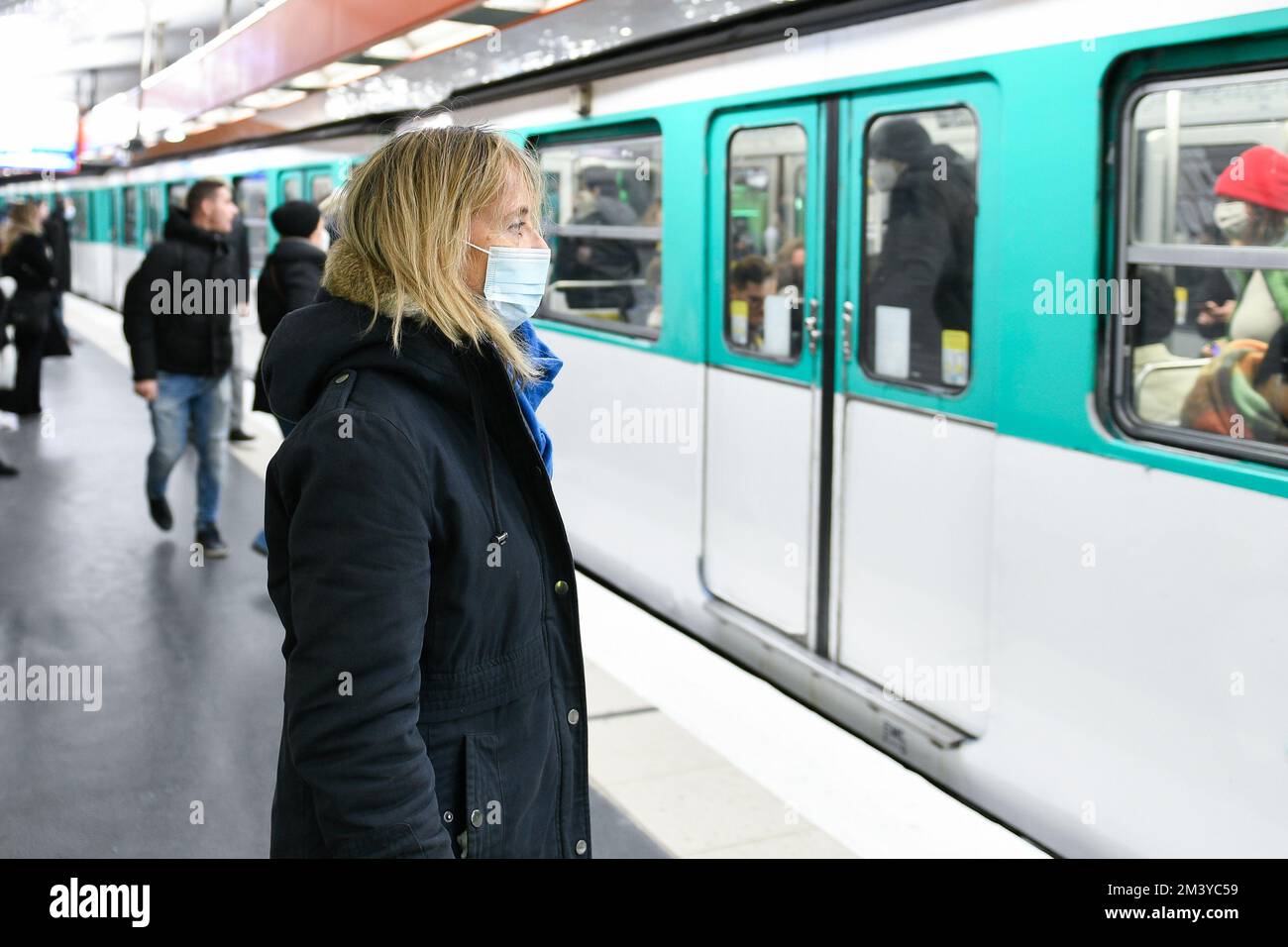 Une personne (femme passager) portant un masque bleu chirurgical dans les transports publics en raison de la pandémie de Covid-19 (coronavirus), à 16 décembre 2022, à Paris. Banque D'Images
