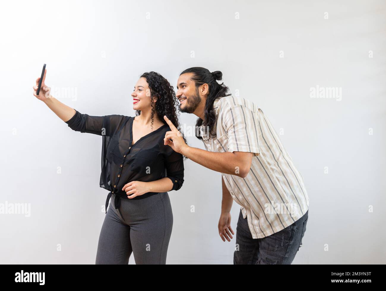 Joyeux couple latin charmant faisant l'auto-photo, montrant le V-signe Banque D'Images