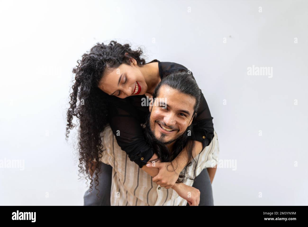 Portrait d'un jeune couple hispanique beau latin homme portant sa jolie petite amie sur le dos Banque D'Images