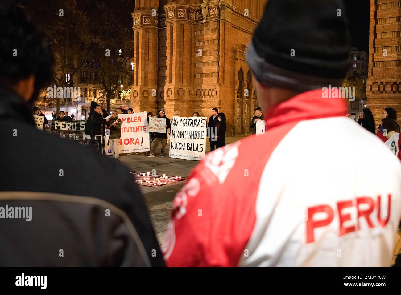 Un homme portant un manteau péruvien participe au rassemblement à la  mémoire des 20 personnes tuées au Pérou. Samedi 17 décembre à l'Arc de  Triomphe de Barcelone, des dizaines de Péruviens ont