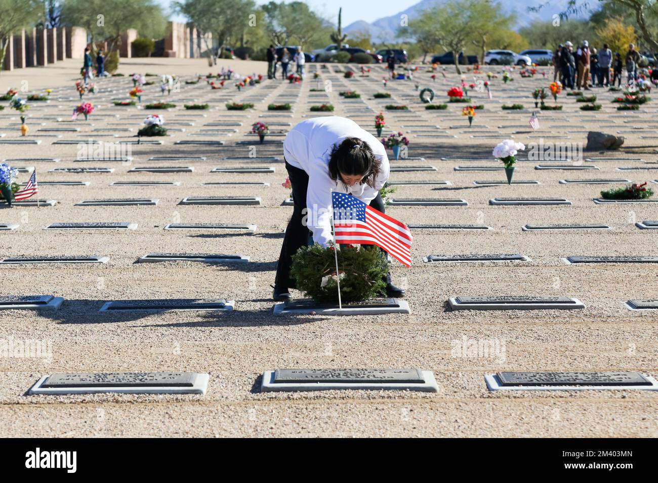 Une femme pose une couronne sur une pierre d'honneur lors des couronnes annuelles à travers l'Amérique, qui dépose des couronnes de vacances pour honorer et se souvenir des anciens combattants et de nos héros countryÕs tombés au cimetière national de Phoenix, Arizona, États-Unis, sur 17 décembre 2022. Des couronnes à travers l'Amérique coordonnent les cérémonies de pose de couronnes dans plus de 3 000 endroits aux États-Unis et à l'étranger à la même date et à la même heure dans tous les endroits pour coordonner avec celle du cimetière national d'Arlington. (Photo par: Alexandra Buxbaum/Sipa USA) crédit: SIPA USA/Alay Live News Banque D'Images