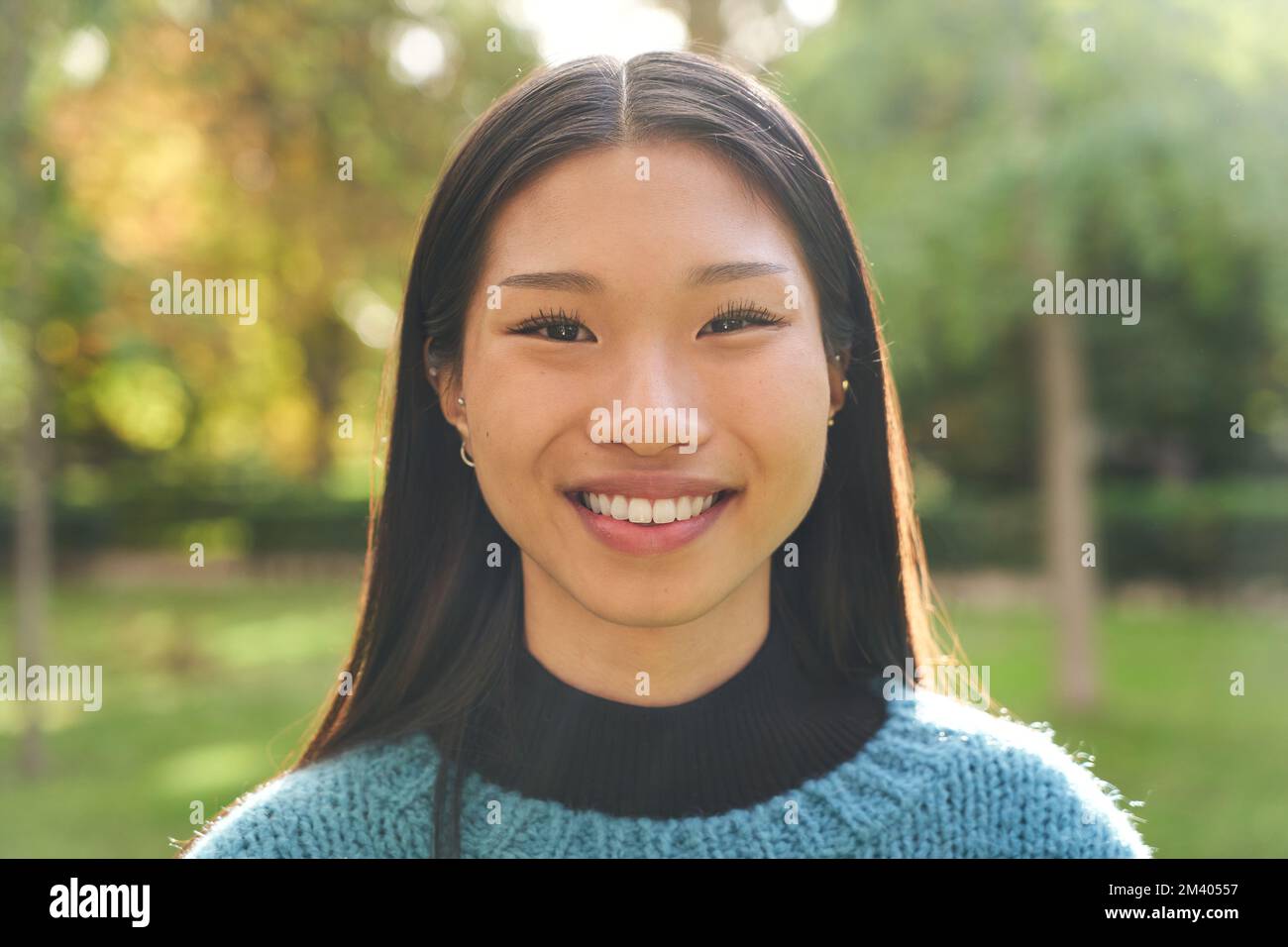 Portrait d'une jeune femme asiatique souriante et regardant l'appareil photo à l'extérieur. Bonne fille chinoise. Banque D'Images