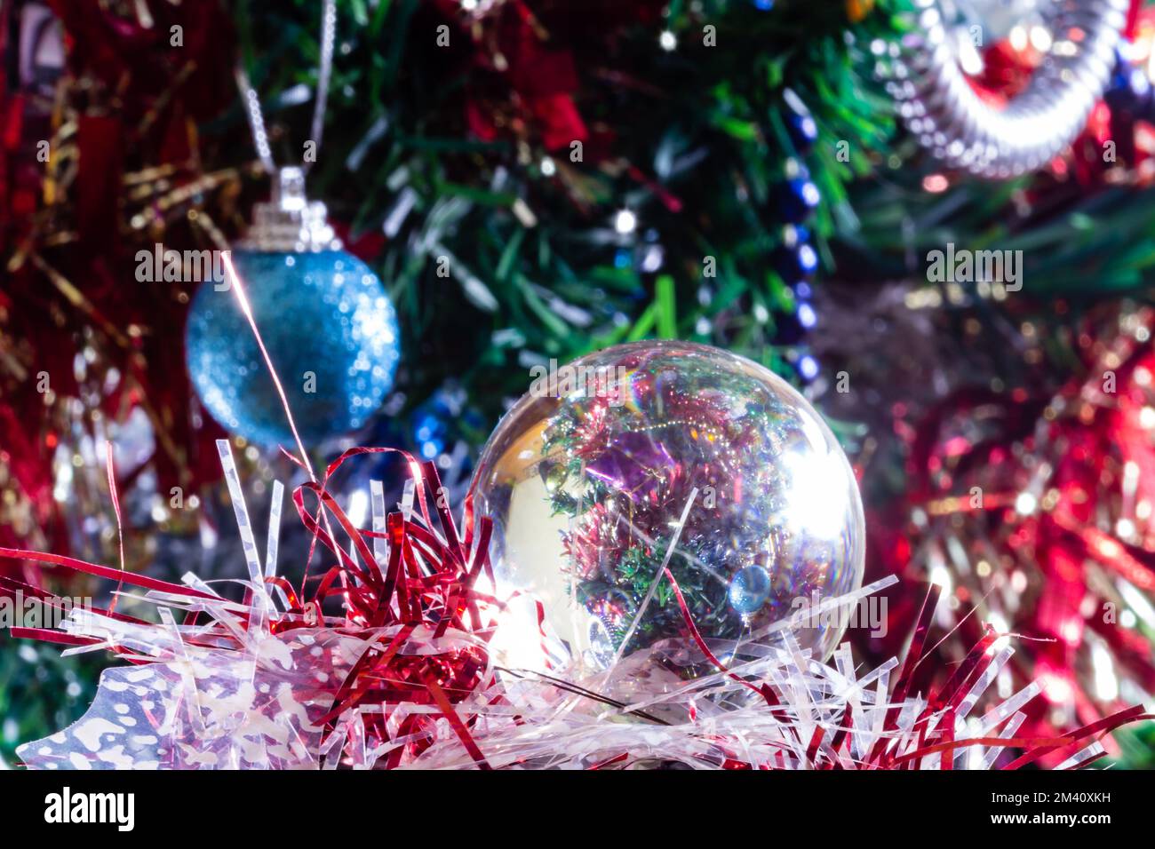 Décorations de Noël sur un arbre à travers la boule d'objectif, macro-shot gros plan Banque D'Images