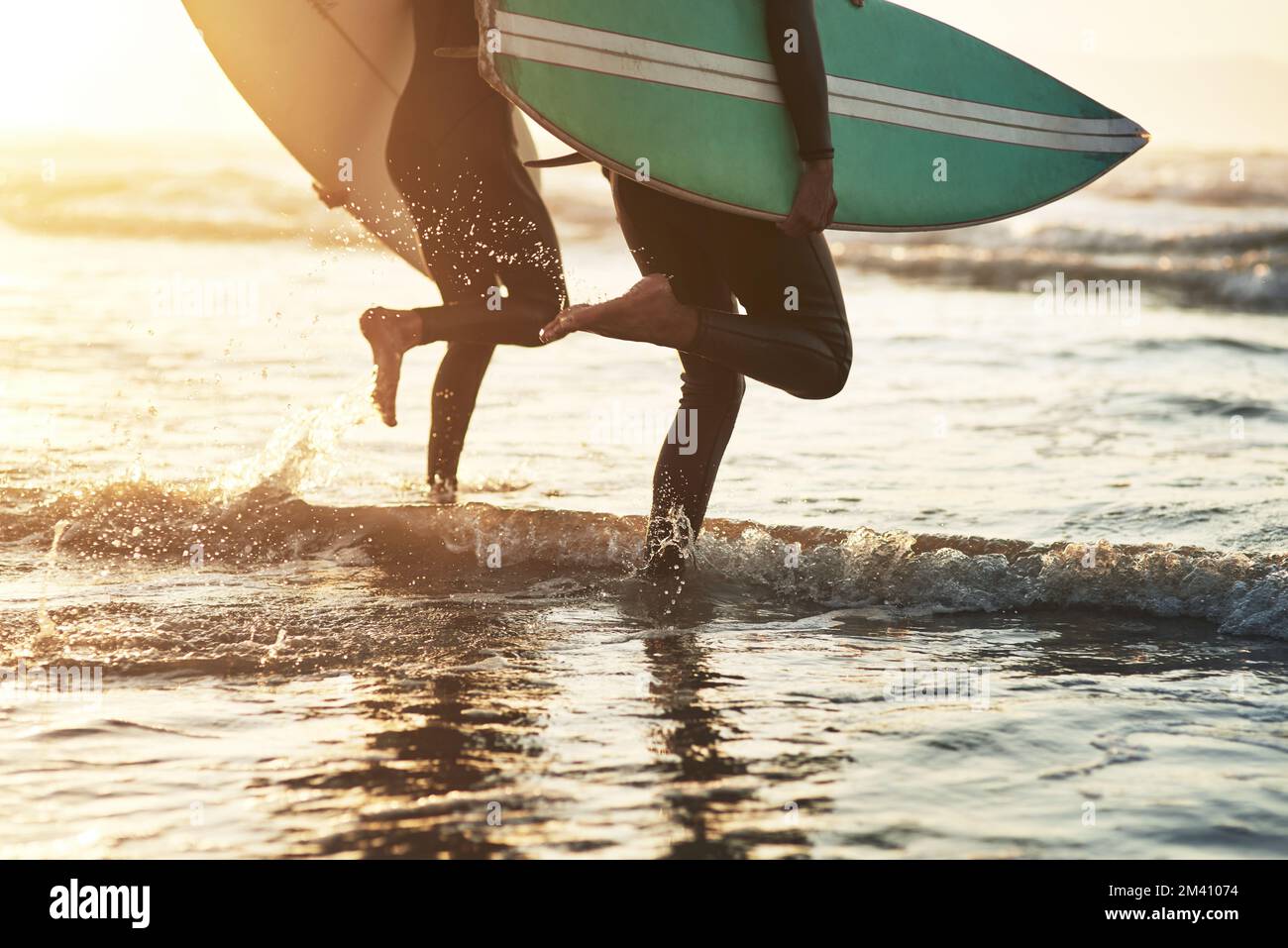Nous trouvons la liberté dans les eaux qui font rage. un jeune couple méconnaissable qui fait du surf à la plage. Banque D'Images