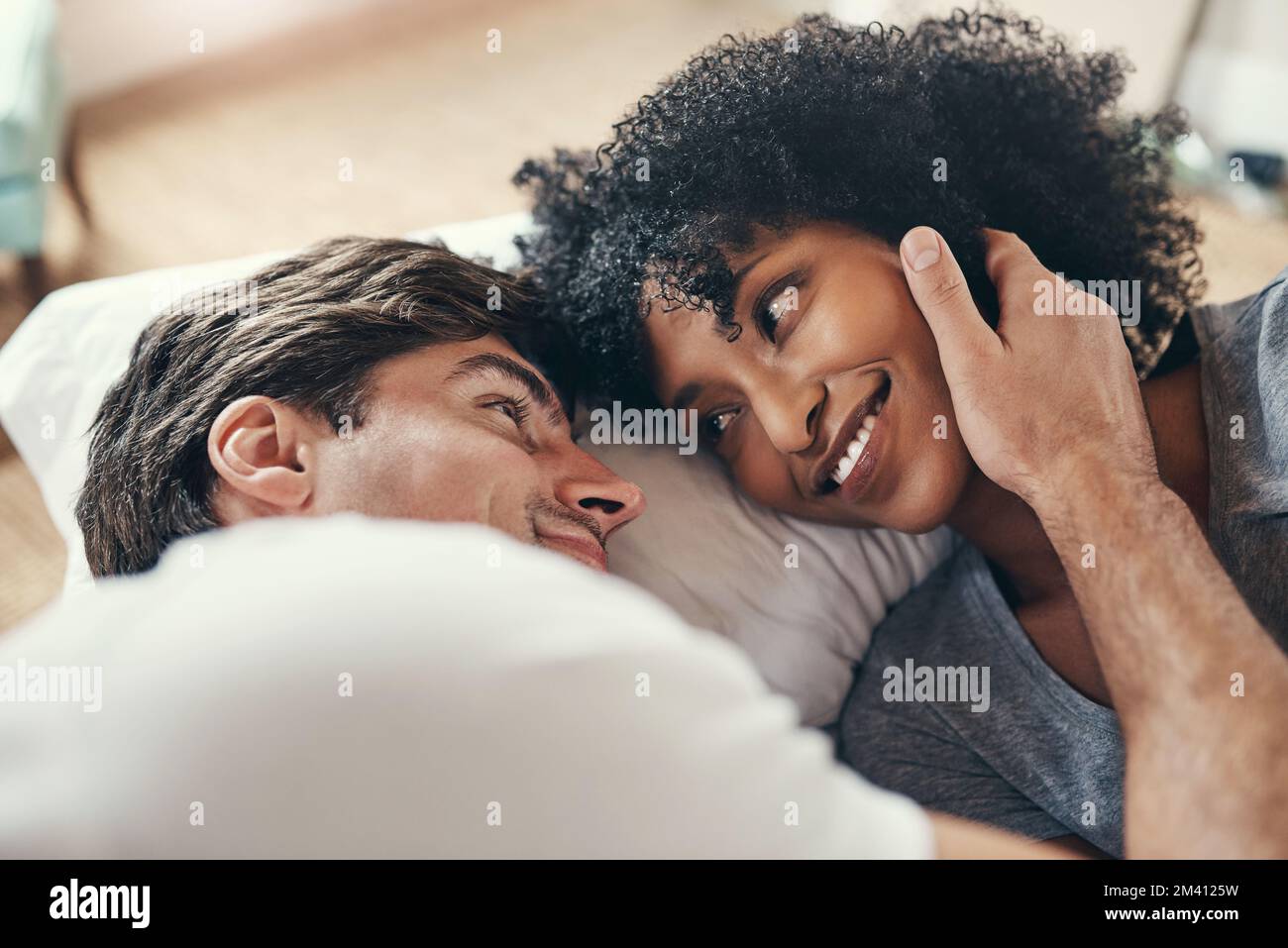 Se réveiller à côté de ma fille de rêve. un jeune couple affectueux passe un moment de qualité ensemble dans sa chambre à la maison. Banque D'Images