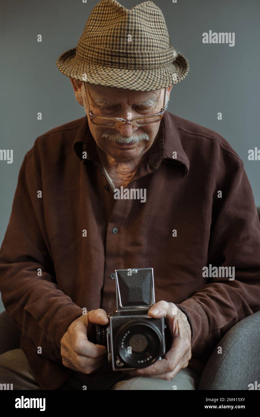 Un vieux photographe avec un appareil-photo de format moyen dans ses mains. Banque D'Images