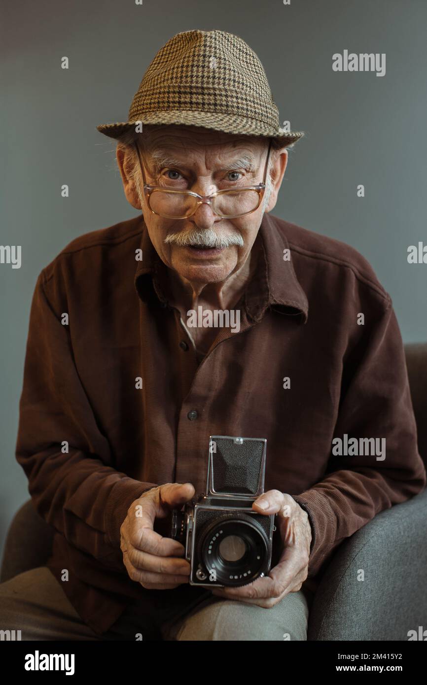 Un vieux photographe avec un appareil-photo de format moyen dans ses mains. Banque D'Images