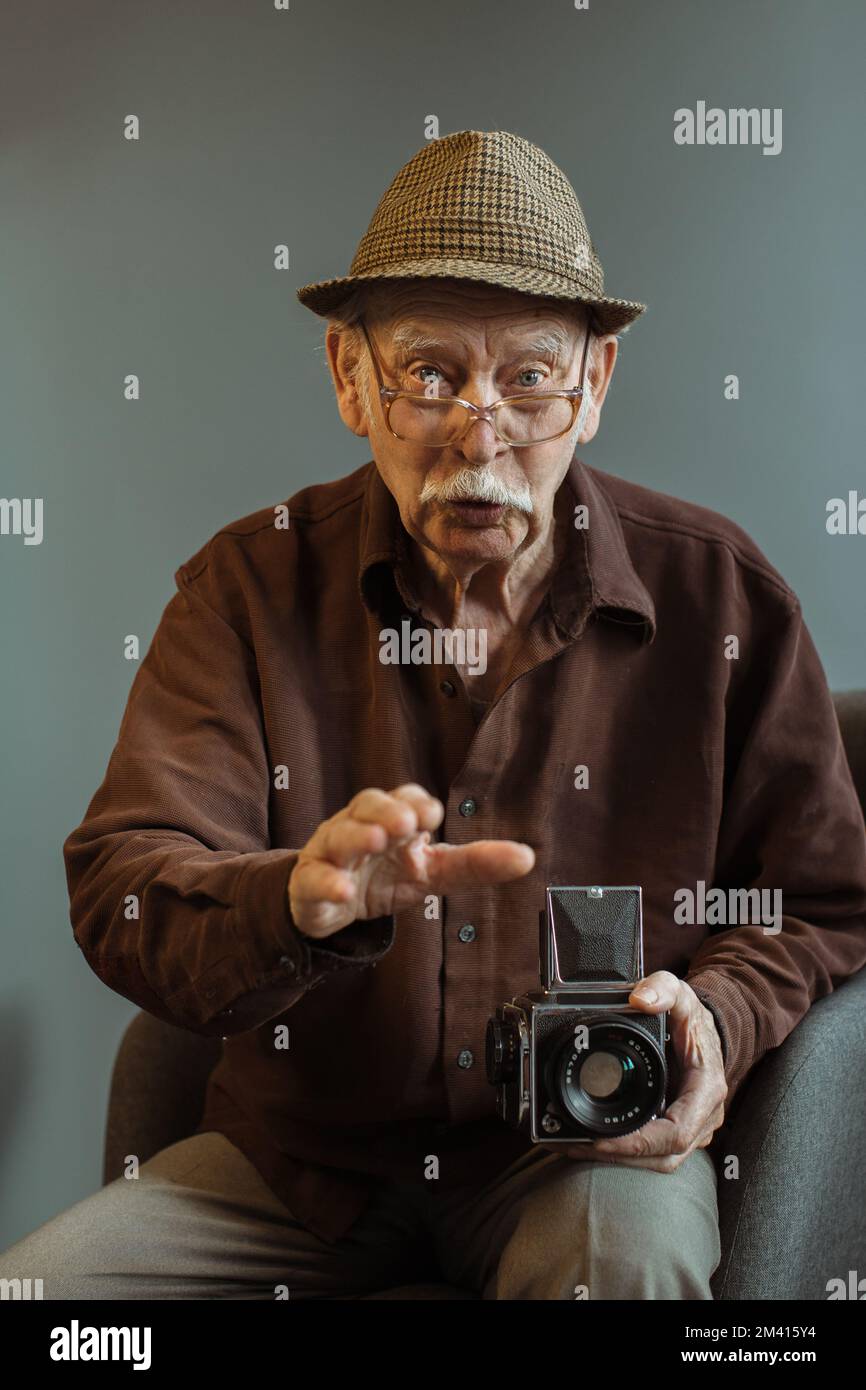 Un vieux photographe avec un appareil-photo de format moyen dans ses mains. Banque D'Images