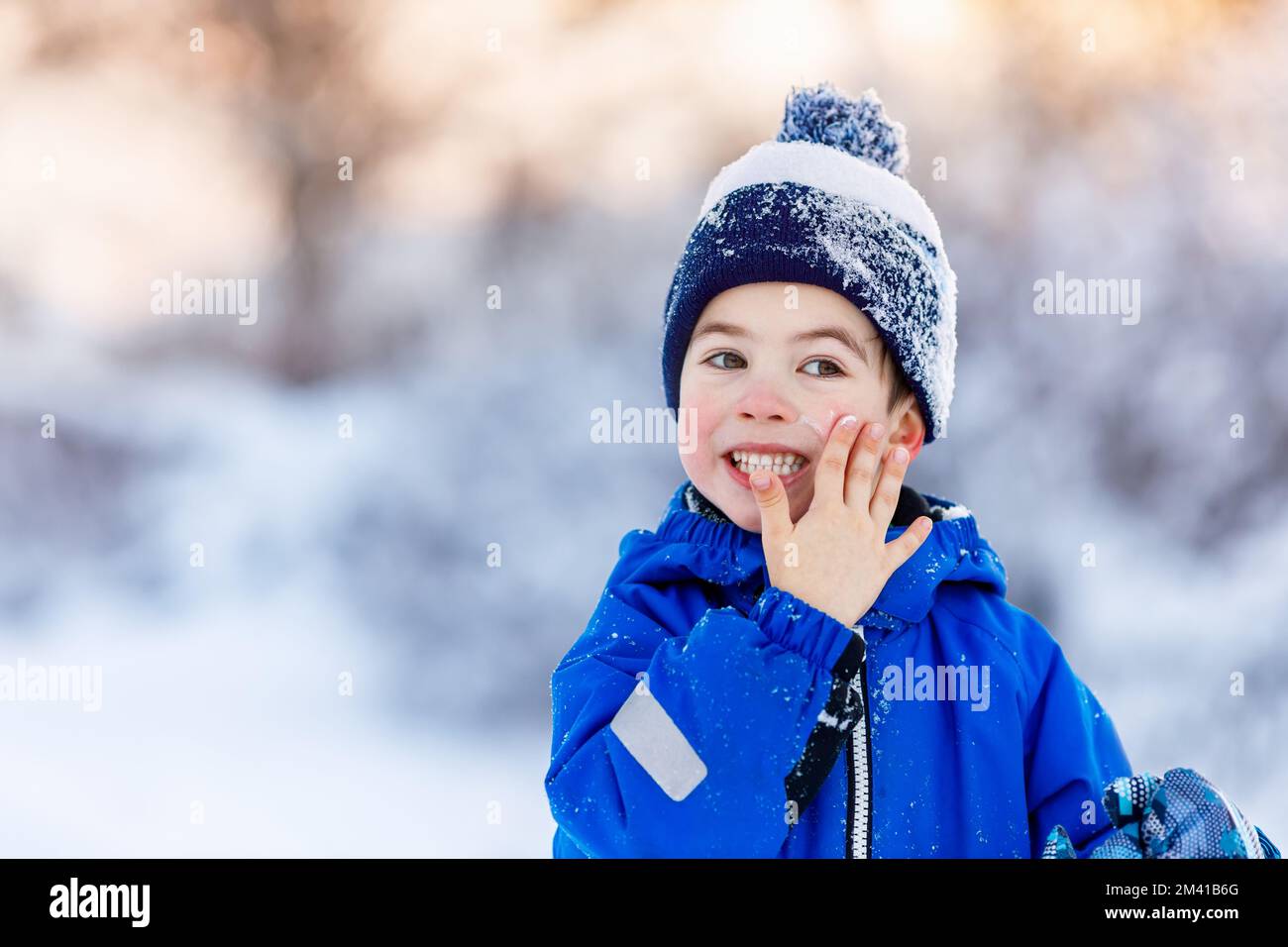 portrait d'un petit garçon mignon appliquant de la crème froide sur le visage Banque D'Images