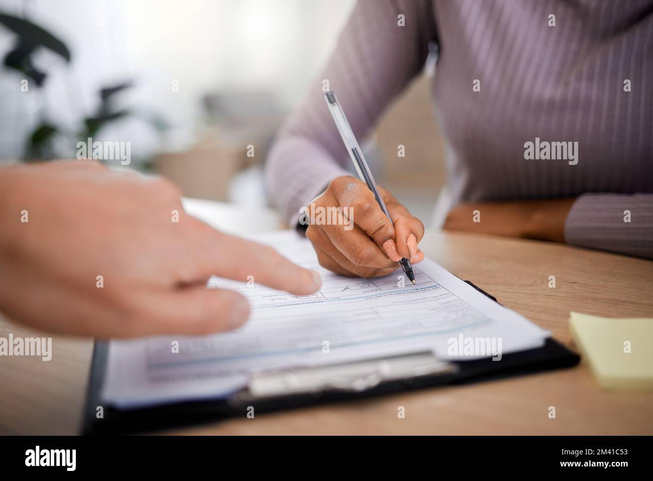 Soins de santé, documents et écriture avec la main d'un patient à l'aide d'un stylo dans un cabinet médical pour les informations d'assurance. Hôpital, papier ou contrat avec un Banque D'Images