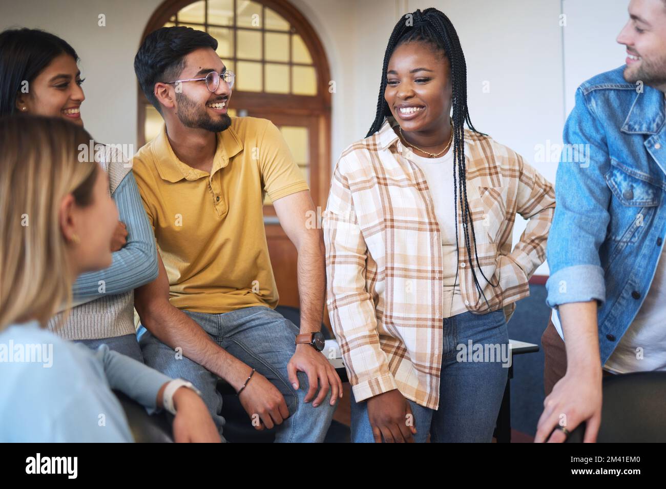 Université, projet et groupe d'étudiants en discussion pour la recherche, l'étude ou l'information en classe. Heureux, diversité et amis parlant Banque D'Images