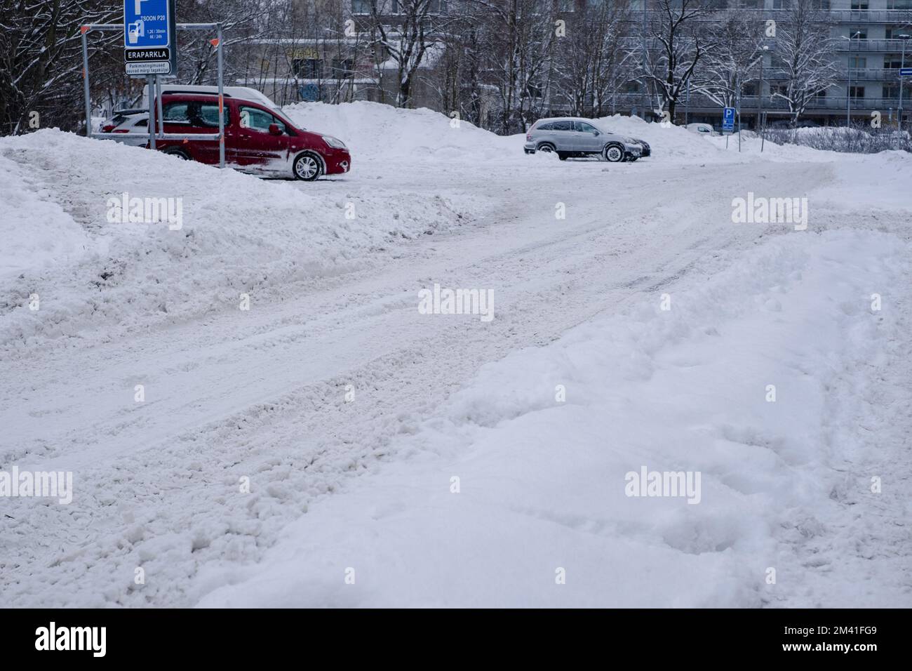 Tallinn, Estonie - 13 décembre 2022: Conditions météorologiques difficiles. Rue et trottoir sous des amas de neige. Circulation dangereuse. Banque D'Images