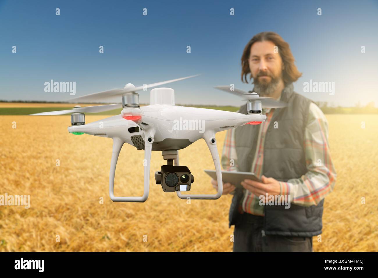 L'agriculteur contrôle le drone avec une tablette. Une agriculture intelligente Banque D'Images