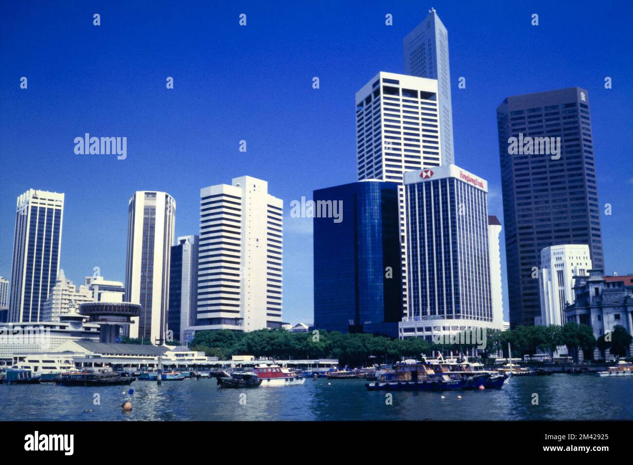 Vue historique de Marina Bay et du fleuve de Singapour et de la ville de Singapour Skyline de la région centrale avec des bateaux et d'anciens bateaux de Bumboat amarrés en face, Singapour 1990 Banque D'Images