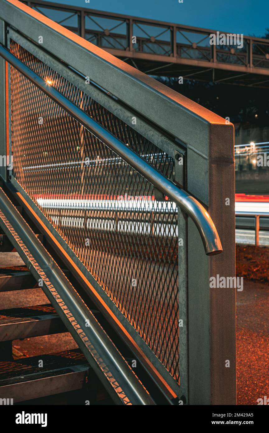 Garde-corps sur l'escalier devant les traînées de lumière Banque D'Images