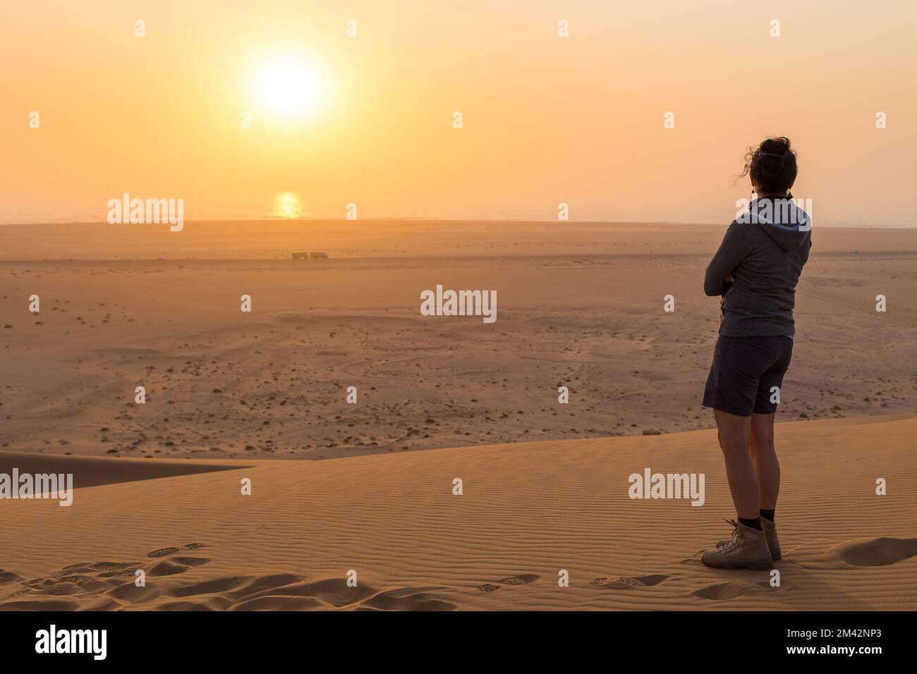 Swakopmund, Namibie - 03 octobre 2018 : fille dans les dunes. Coucher de soleil sur la partie nord du désert du Namib. Désert au large de la côte de l'Océan Atlantique Banque D'Images