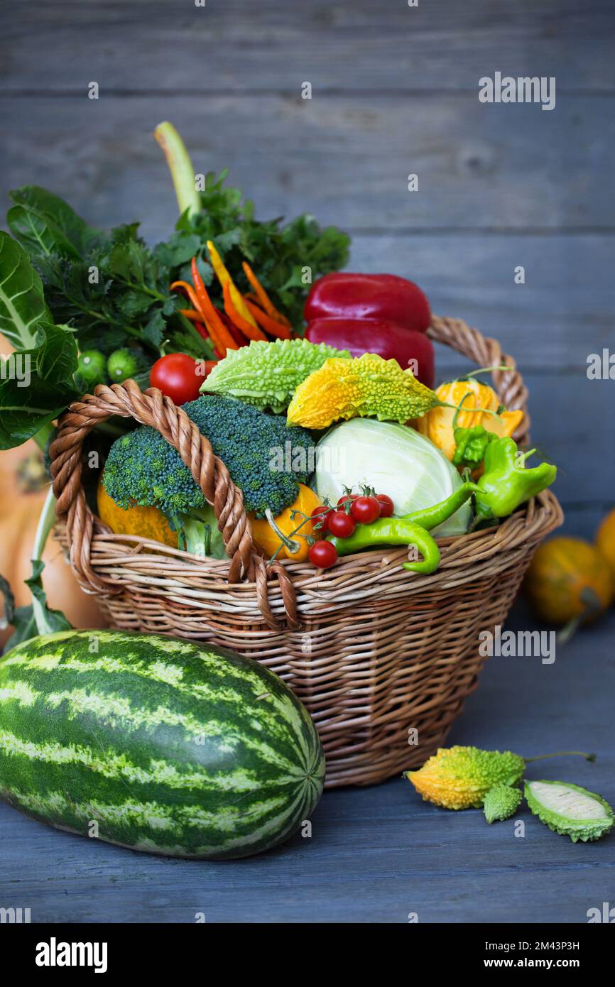 Un grand panier de fruits et légumes variés sur fond de bois Photo Stock -  Alamy