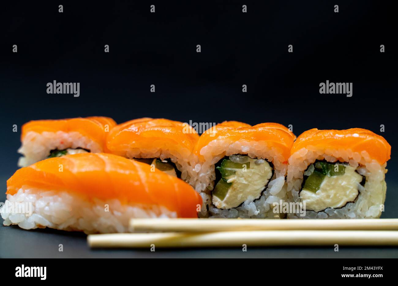 Cuisine japonaise. Sushi sur fond noir. Petits pains au poisson rouge, Philadelphie. Banque D'Images