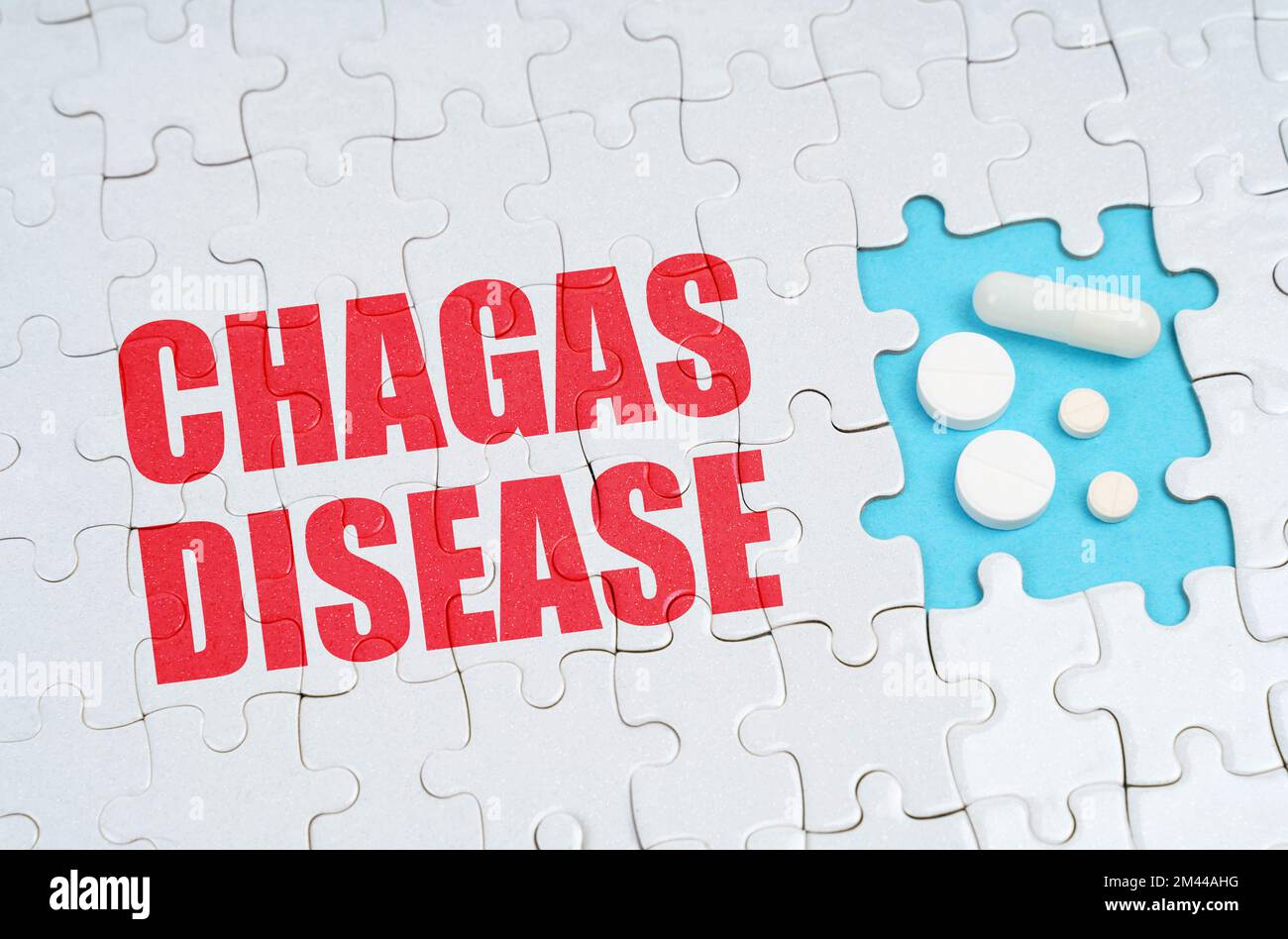 Concept médical. Sur les puzzles il y a une inscription - maladie de Chagas, sur un fond bleu des pilules. Banque D'Images