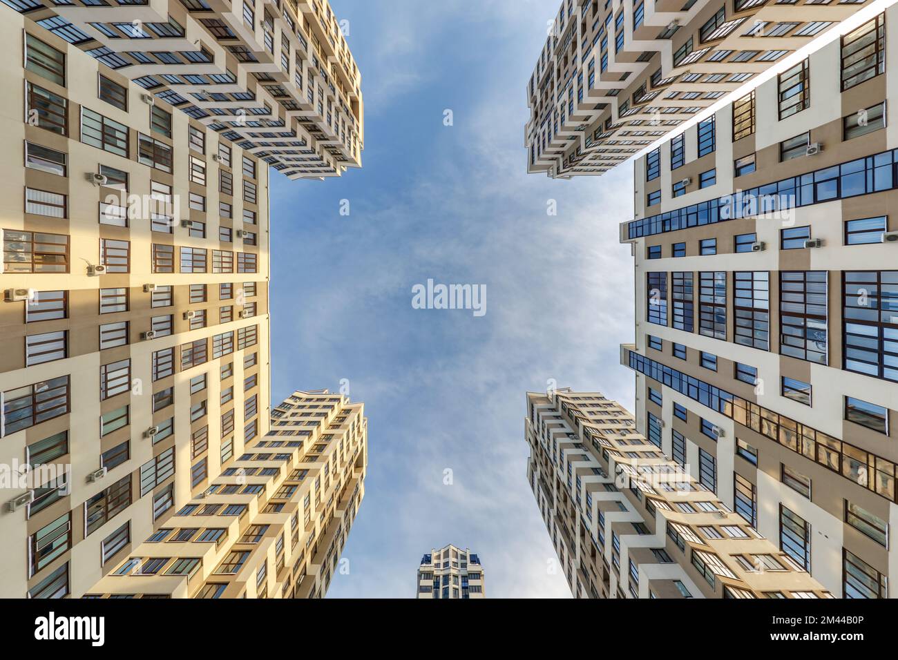 vue du sol au ciel bleu parmi les gratte-ciel, regardez la maison de bas en haut Banque D'Images